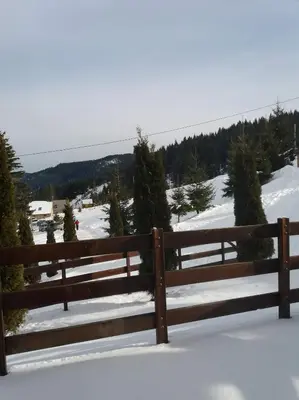 a wooden fence with snow on the ground at Lux - Apartment Snow Oasis in Vlasic