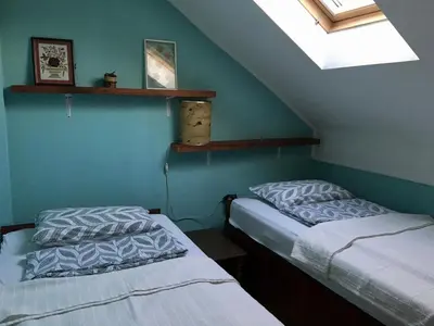 two twin beds in a room with a window at Kula hacienda in Tuzla