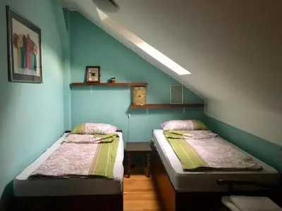 two beds in a room with blue walls at Kula hacienda in Tuzla
