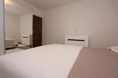 a white bedroom with a large bed and a mirror at Villa Una Paradise in Bihać