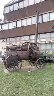 an old steam engine on display in front of a building at Stan na dan Banja Luka in Banja Luka