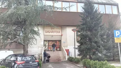 a man walking into a building with a sign on it at Stan na dan Banja Luka in Banja Luka