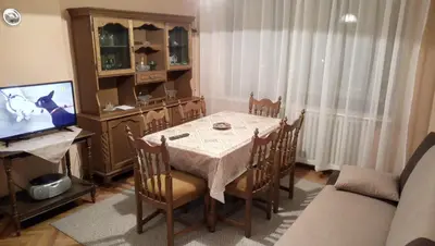 a dining room with a table and a television at Stan na dan Banja Luka in Banja Luka