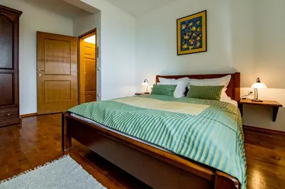 a bedroom with a large bed with green and white sheets at Hotel Sunce Vlašić in Vlasic
