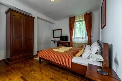 a bedroom with a bed and a dresser and a window at Hotel Sunce Vlašić in Vlasic