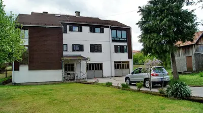 a house with a car parked in front of it at Guesthouse Trikic in Drvar