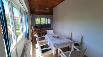 a dining room with a table and white chairs at Guesthouse Trikic in Drvar