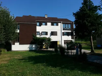 two people standing in front of a house at Guesthouse Trikic in Drvar