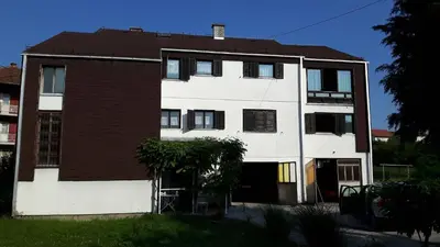 a white building with a brown and white at Guesthouse Trikic in Drvar