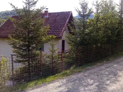 a fence in front of a house with trees at Vikend kuća Careva Ćuprija-apartman in Olovo