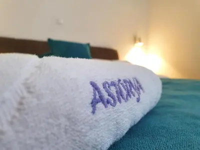a white towel with the word stitch on a bed at Wellness&Spa Hotel Astorya in Banja Luka