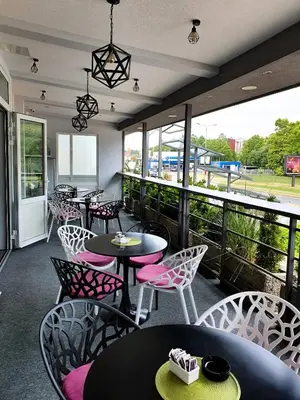 a restaurant with tables and chairs and a balcony at Wellness&Spa Hotel Astorya in Banja Luka