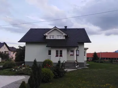 a white house with a black roof at Apartman M. Rados in Kupres