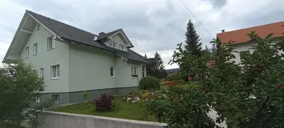 a white house with a black roof at Apartman M. Rados in Kupres
