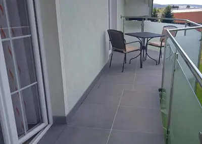 a balcony with a table and chairs and a table at Apartman M. Rados in Kupres