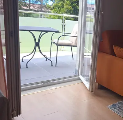 a glass door leading to a patio with a table and a chair at Apartman M. Rados in Kupres