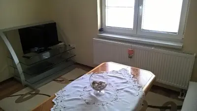 a living room with a table and a tv at Apartman Vesna in Kupres