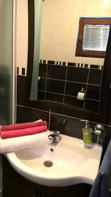 a bathroom sink with a red and white towel on it at Apartman Vesna in Kupres