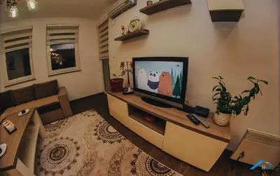 a living room with a flat screen tv on a wall at Brilliant Apartman in Bihać