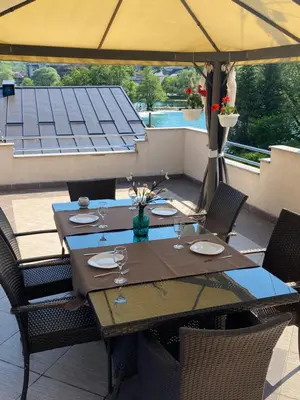 a table with chairs and an umbrella on a patio at Apartman River Una in Bihać