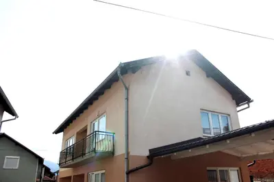 a building with the sun shining on the side of it at Apartman River Una in Bihać