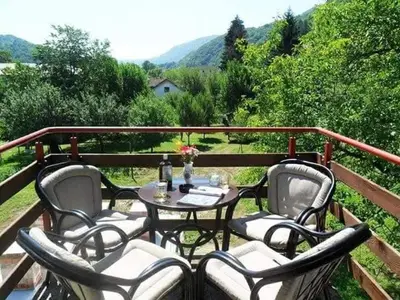 a patio with a table and chairs on a deck at Hostel Topić in Banja Luka