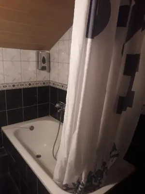 a bathroom with a bath tub with a shower curtain at Hostel Topić in Banja Luka