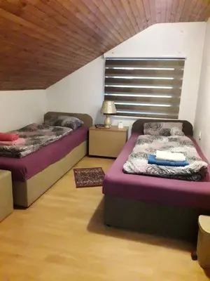 two beds in a room with a wooden ceiling at Hostel Topić in Banja Luka