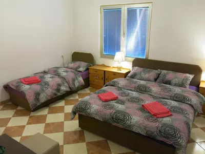 a bedroom with a bed and a bed and a table at Hostel Topić in Banja Luka