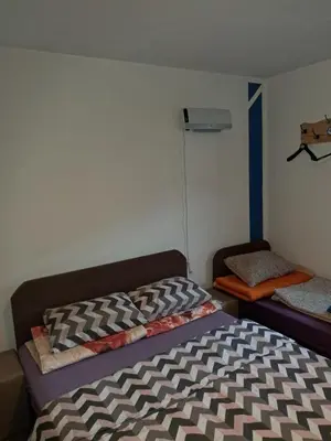 a bedroom with a bed and a couch in it at Hostel Topić in Banja Luka