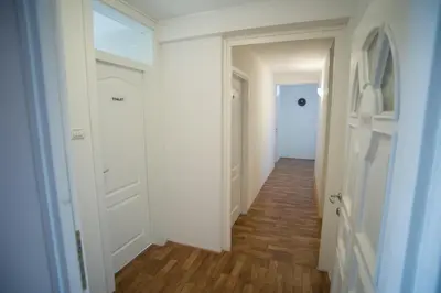 a hallway with white walls and wooden floors at Hostel Larisa in Banja Luka