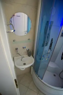 a bathroom with a sink and a shower with a mirror at Hostel Larisa in Banja Luka