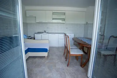 a small kitchen with a table and a table and chairs at Hostel Larisa in Banja Luka