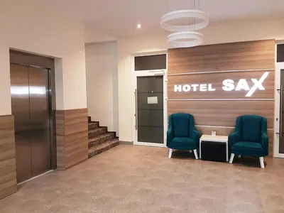 a hotel lobby with two chairs and a hotel say sign at Hotel SAX Gračanica in Gračanica
