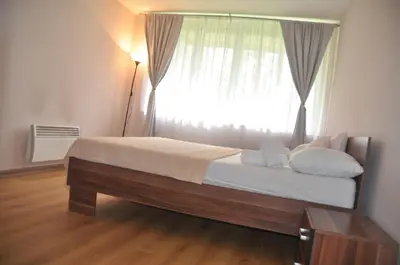 a bedroom with a large bed with a window at Apartman Visoko in Visoko