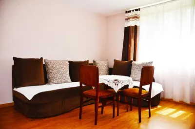 a living room with a couch with chairs and a table at Apartman Visoko in Visoko