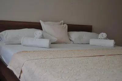 a bed with white pillows and towels on it at Apartman Visoko in Visoko