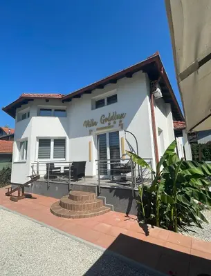 a white building with a patio in front of it at Villa Goldlux in Bihać