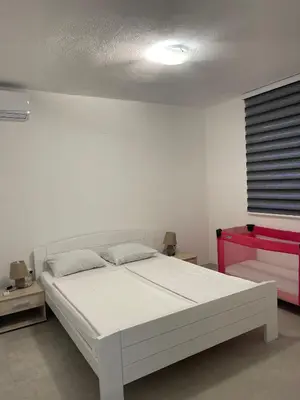 a white bedroom with a white bed in a room at Villa Goldlux in Bihać