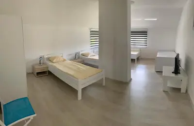 a room with two beds and a tv in it at Villa Goldlux in Bihać