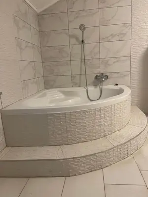 a bath tub with a shower in a bathroom at Villa Goldlux in Bihać