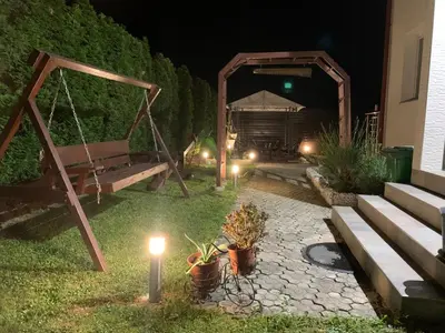 a garden at night with a swing and lights at Villa Goldlux in Bihać