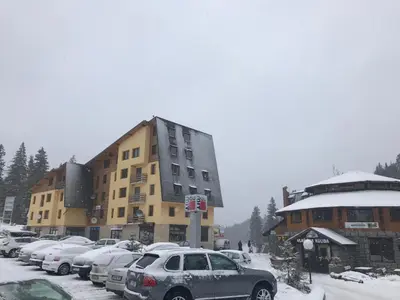 a parking lot with cars parked in front of a building at Apartment Love in Vlasic