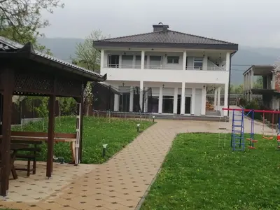 a large white house with a playground in the yard at Villa Al Nemah in Bihać