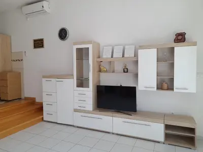 a kitchen with white cabinets and a flat screen tv at Villa Al Nemah in Bihać