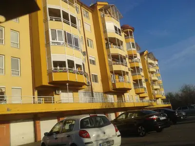 a yellow building with cars parked in front of it at Apartment 3M in Banja Luka