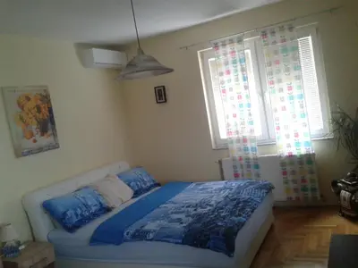 a bedroom with a bed and two windows at Apartment 3M in Banja Luka