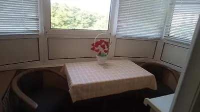 a small table with a vase of flowers on it at Apartment 3M in Banja Luka