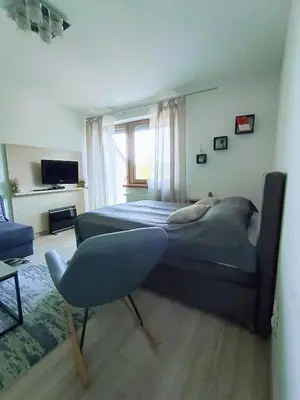 a bedroom with a bed and a chair and a window at Vlašićka priča Eko Fis in Vlasic