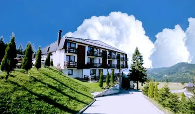a house on top of a hill with trees and clouds at Vlašićka priča Eko Fis in Vlasic